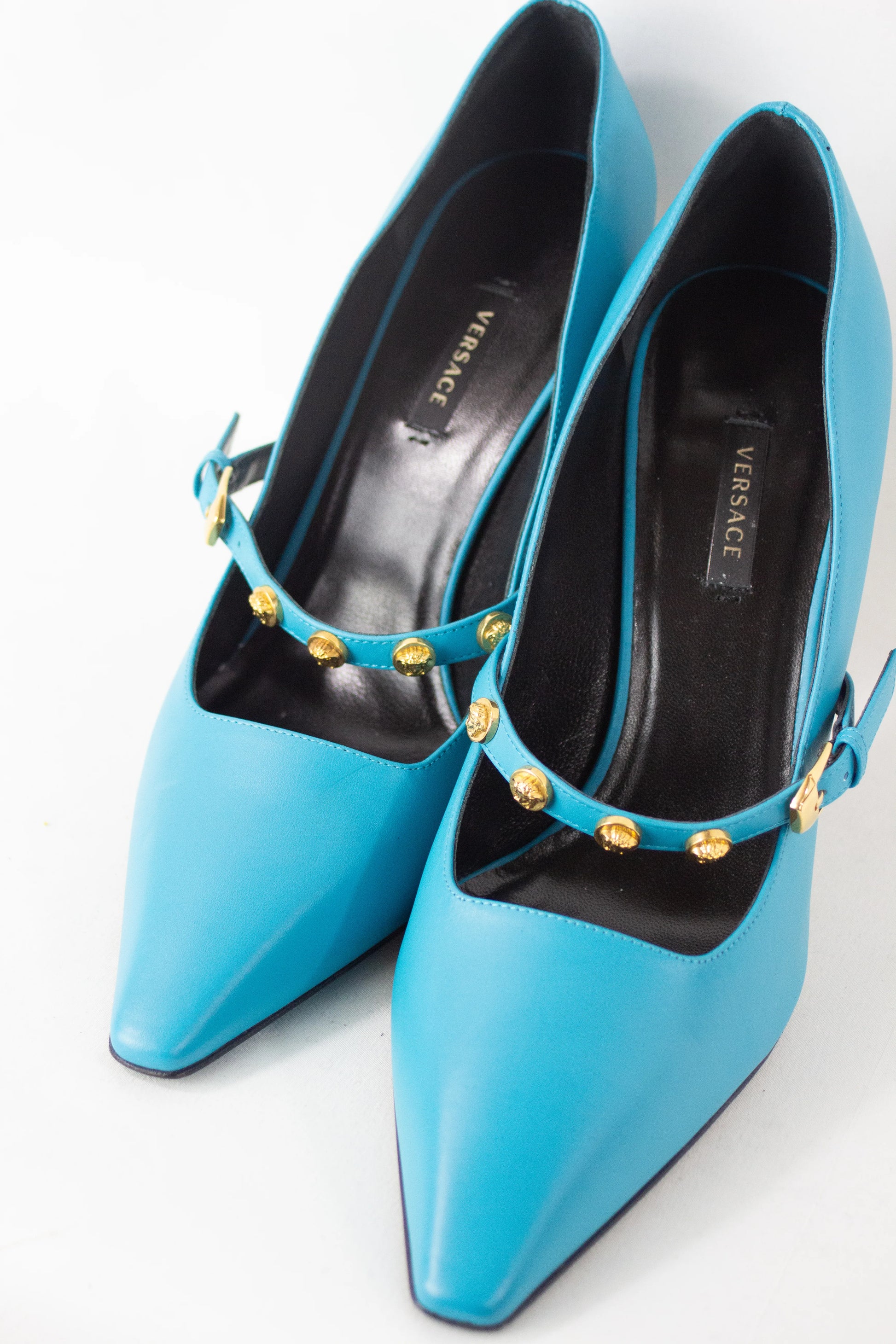 Teal pumps with Medusa logo