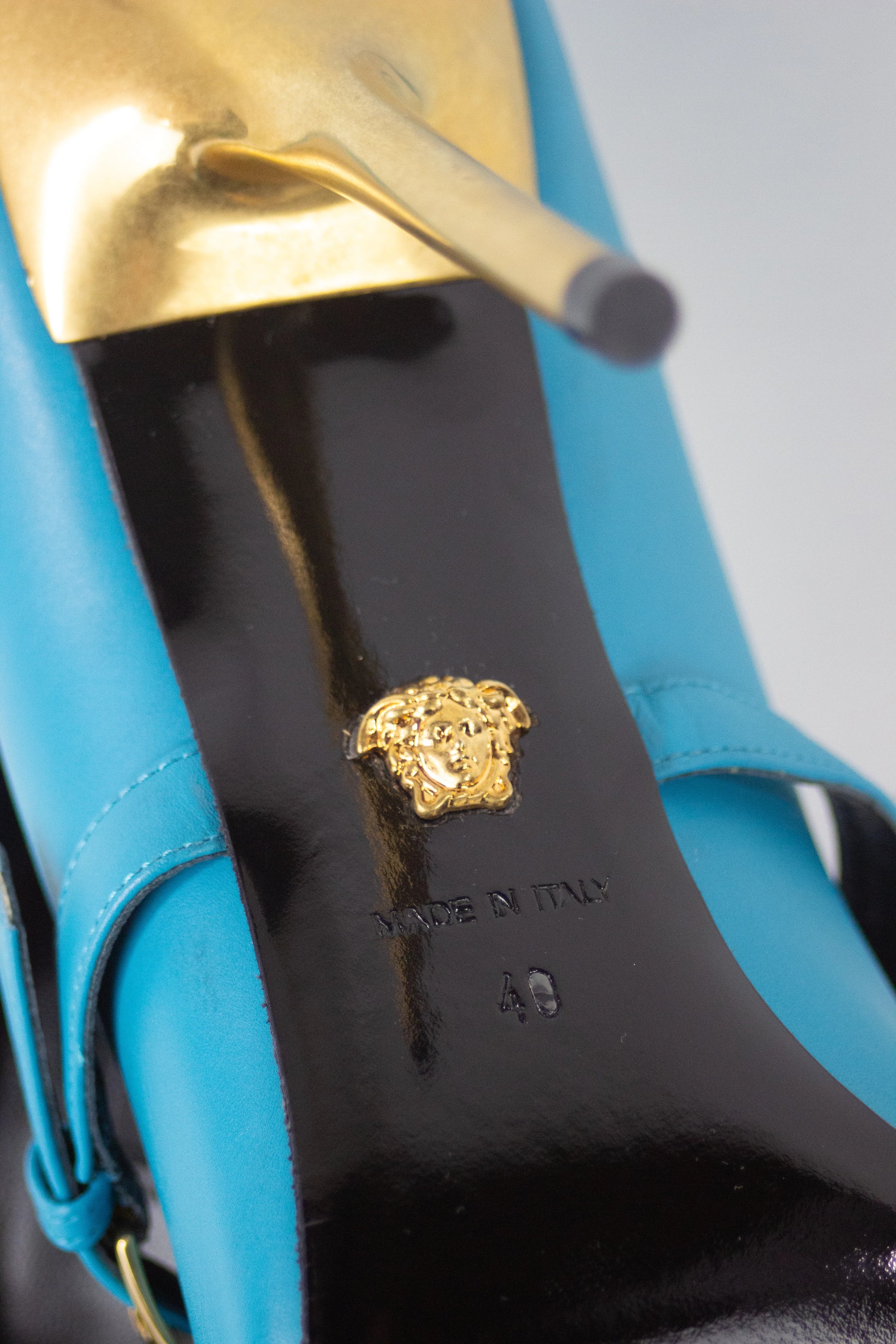 Teal pumps with Medusa logo