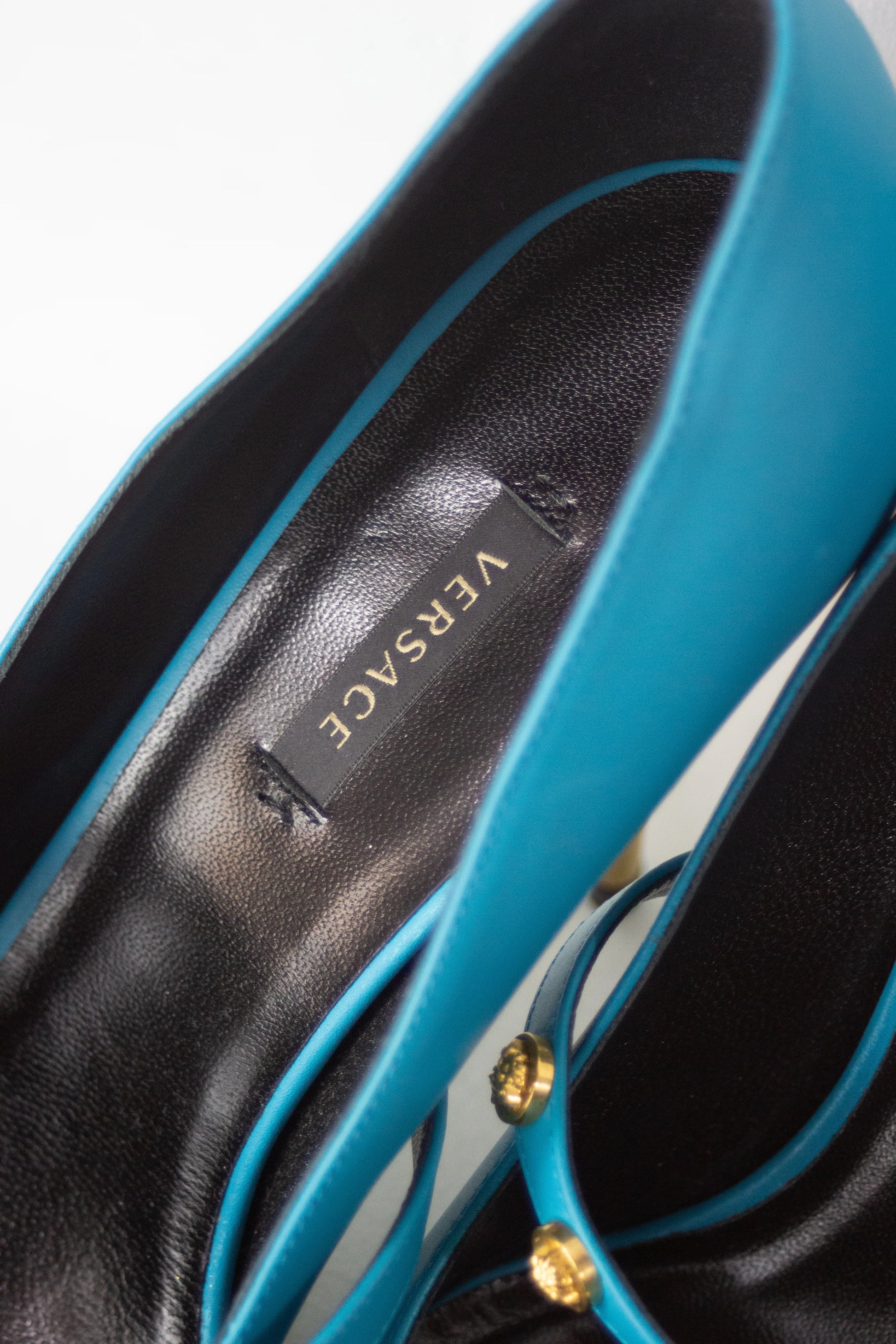 Teal pumps with Medusa logo